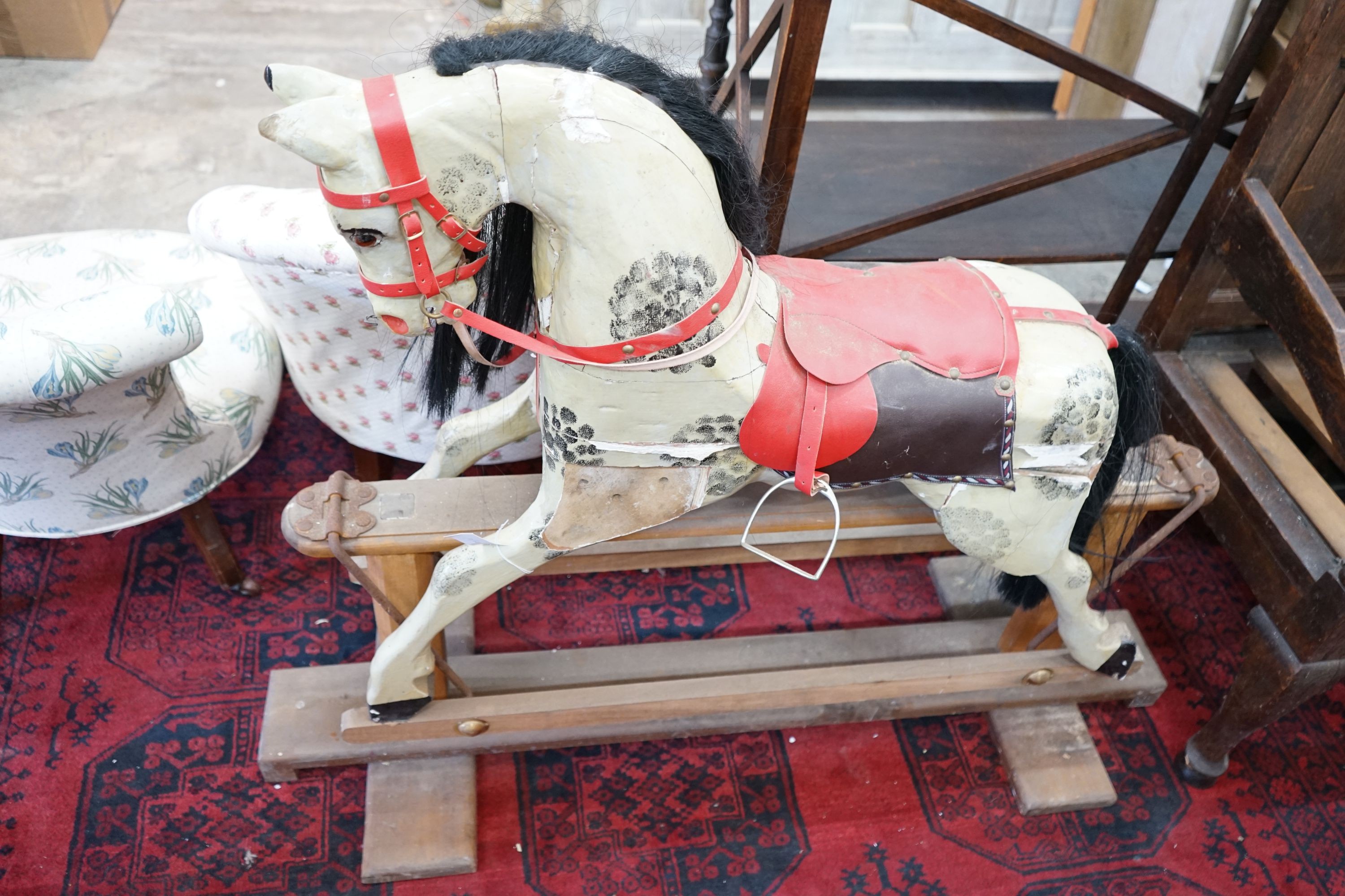 An Ayres type dappled rocking horse on pine safety frame, length 135cm
